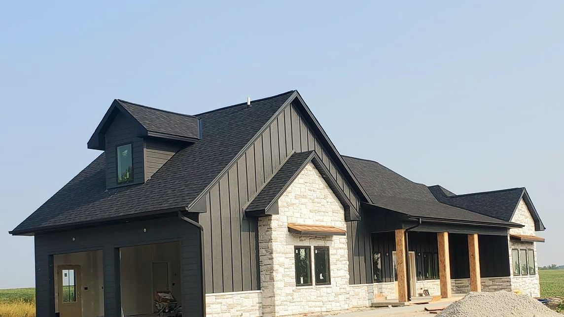 A large white house with a black roof is being built. Independence Built Custom Home Builder in Nebraska