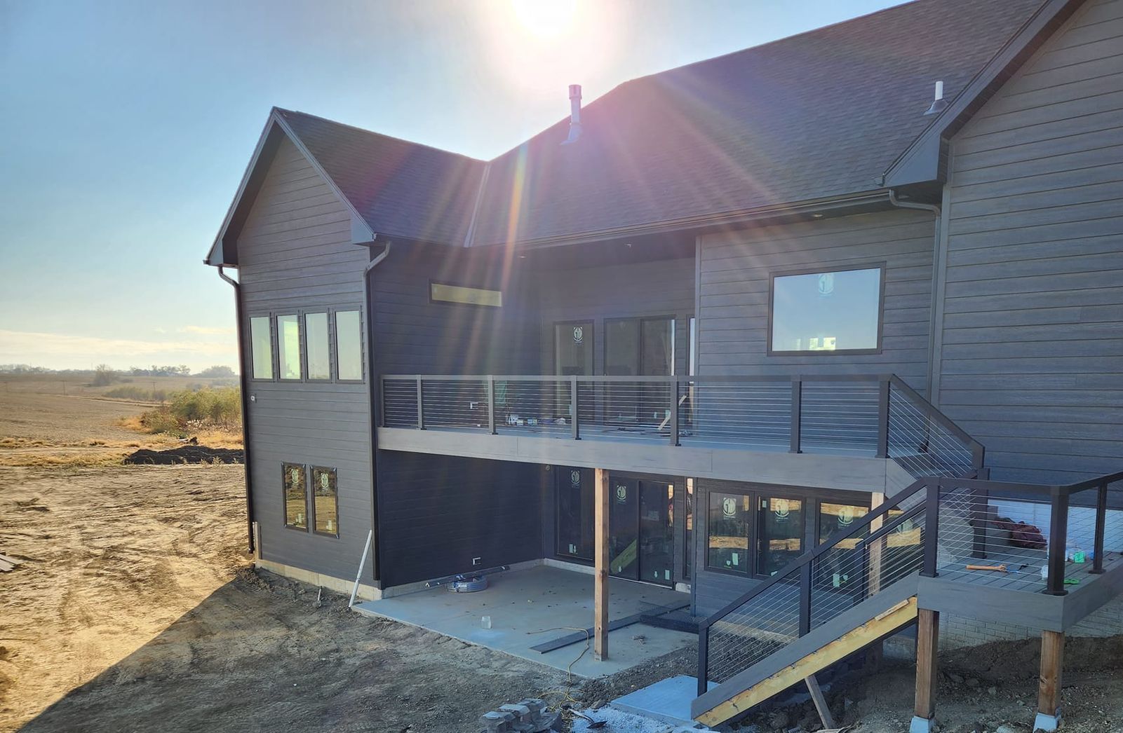 The back of a house with a large deck and stairs.