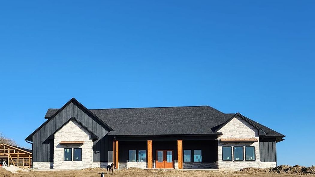 A large house under construction with a blue sky in the background.