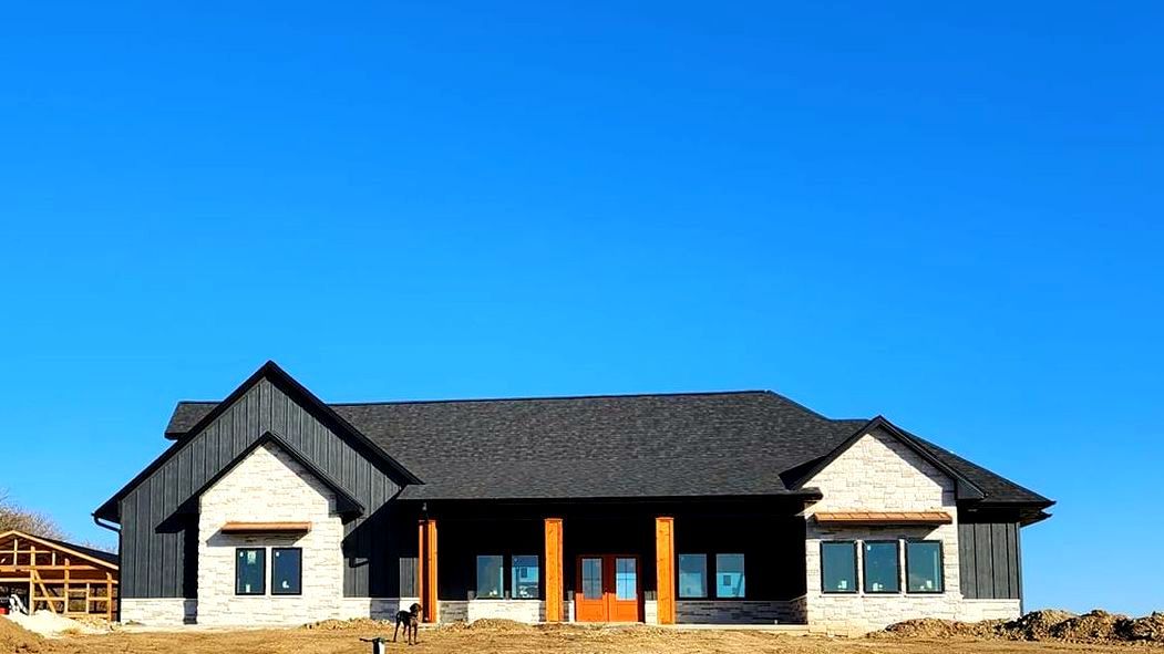 A large house is being built on a hill with a blue sky in the background. Independence Built Custom Home Builder in Nebraska