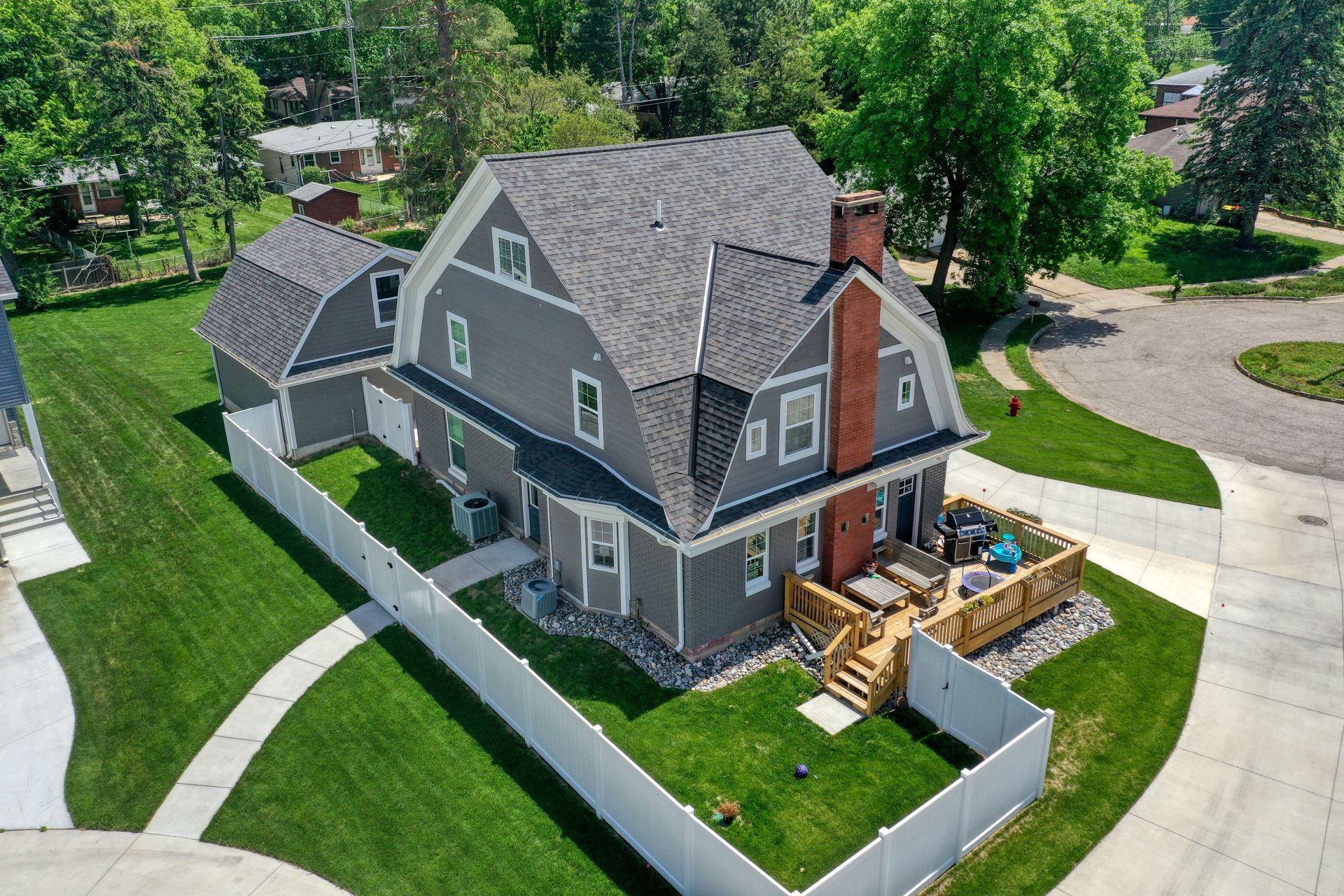 An aerial view of a house with a white fence around it.