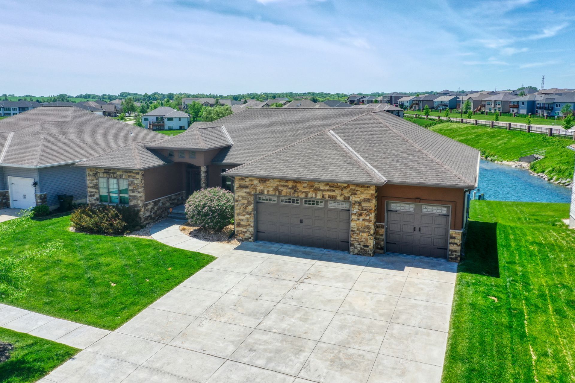 An aerial view of a house with two garages and a large driveway.