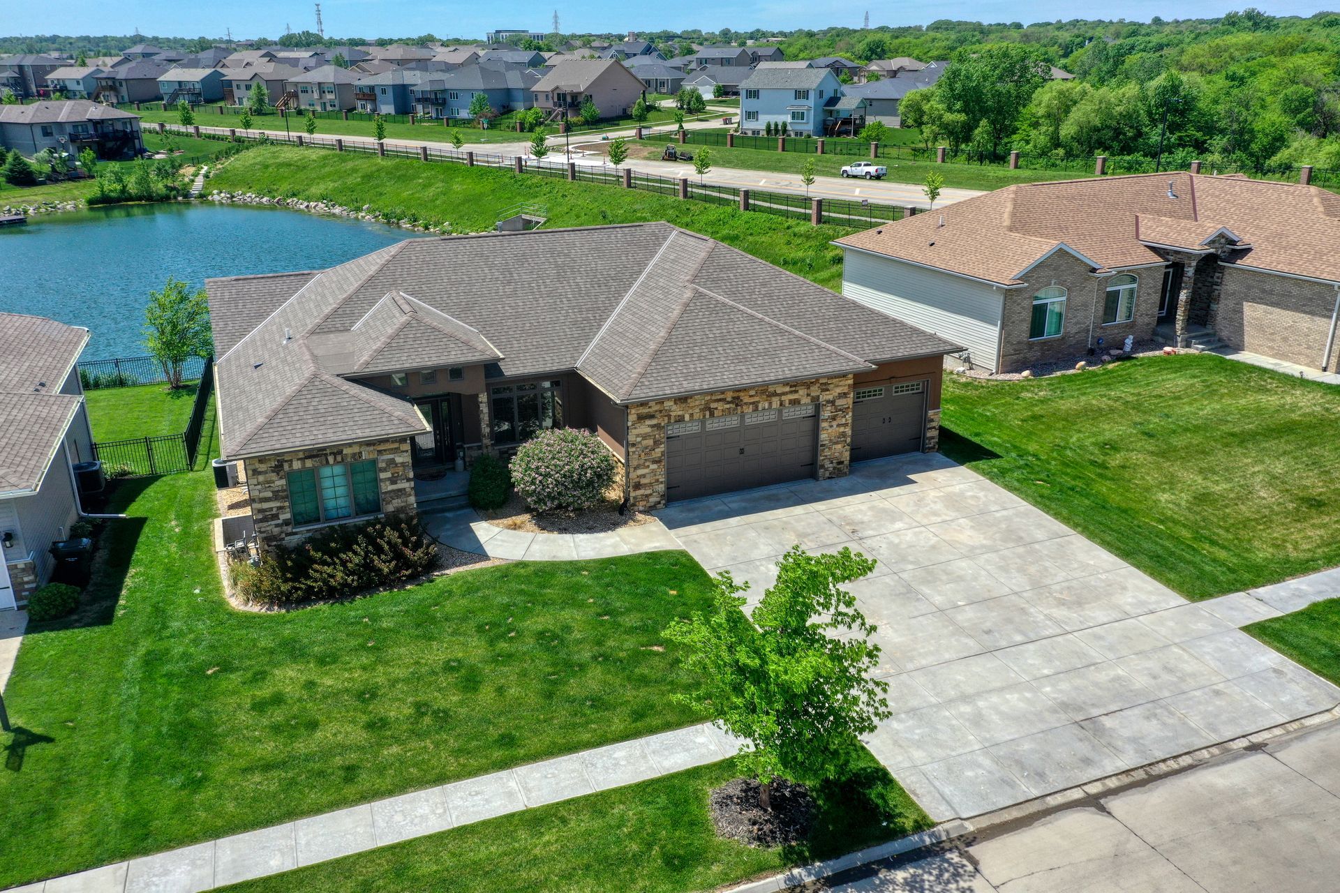 An aerial view of a house in a residential area with a lake in the background.