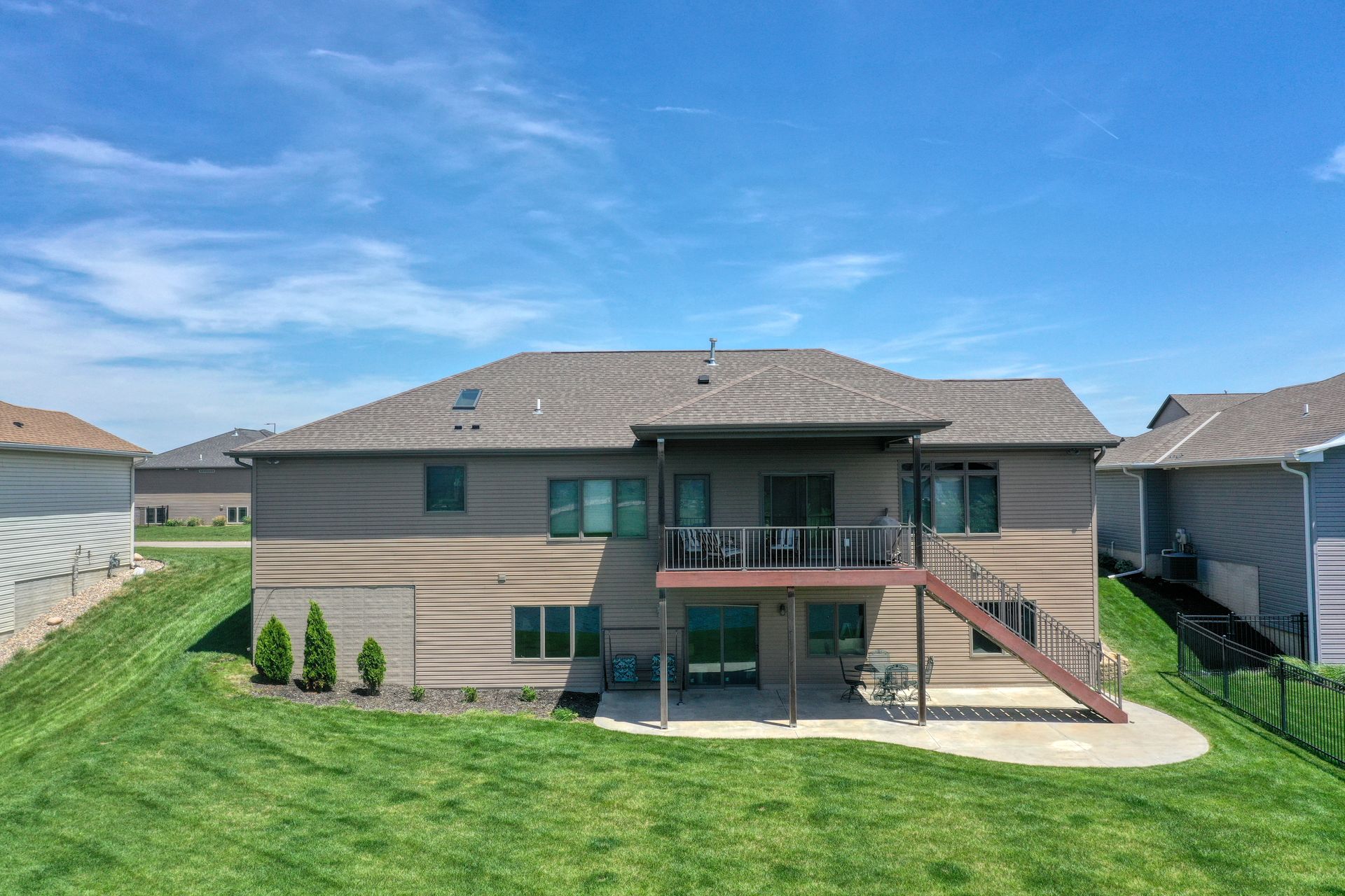 The back of a house with a large lawn in front of it.
