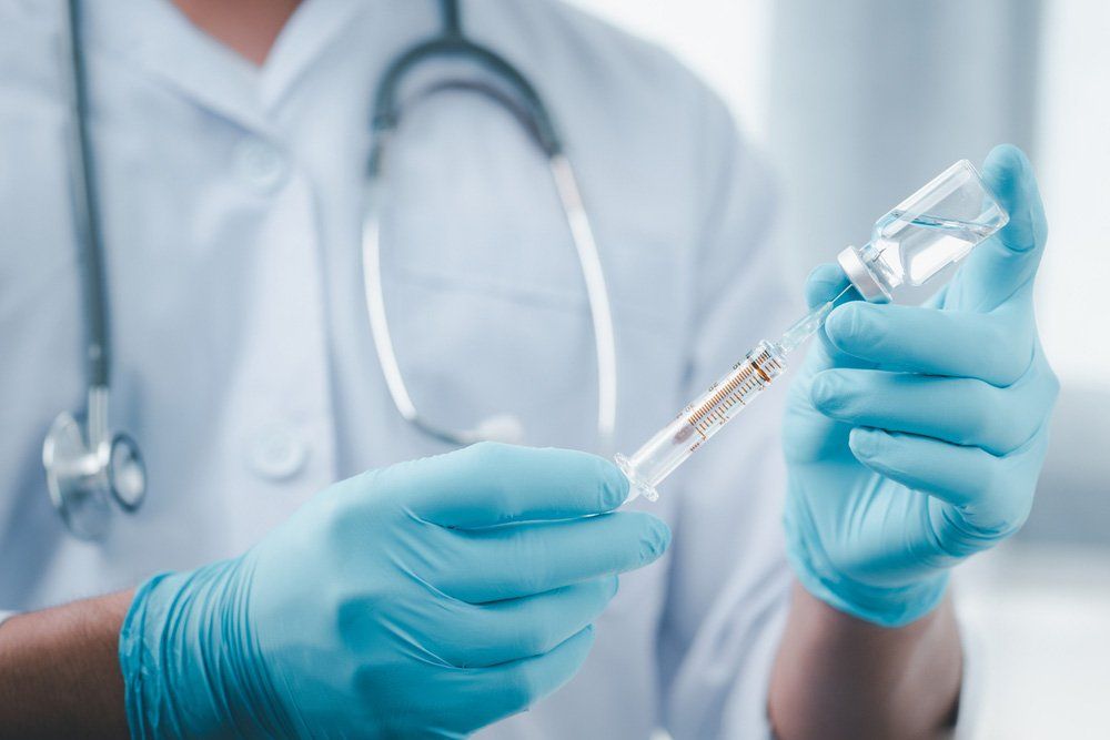 Doctor Holding A Syringe With Liquid Vaccines — Deception Bay Doctors In Deception Bay, QLD
