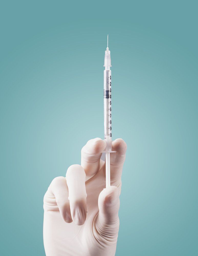 Doctor's Hands Holding Syringe Closeup On Green Background — Deception Bay Doctors In Deception Bay, QLD