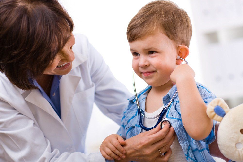 Senior Female Doctor Examining Smiling child — Deception Bay Doctors In Deception Bay, QLD
