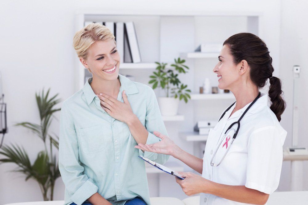 Pink Awareness Ribbon Against Patient Smiling To Her Doctor — Deception Bay Doctors In Deception Bay, QLD