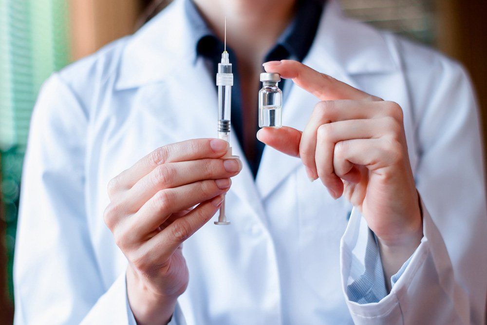 Nurse Holding Vaccination And Injection — Deception Bay Doctors In Deception Bay, QLD