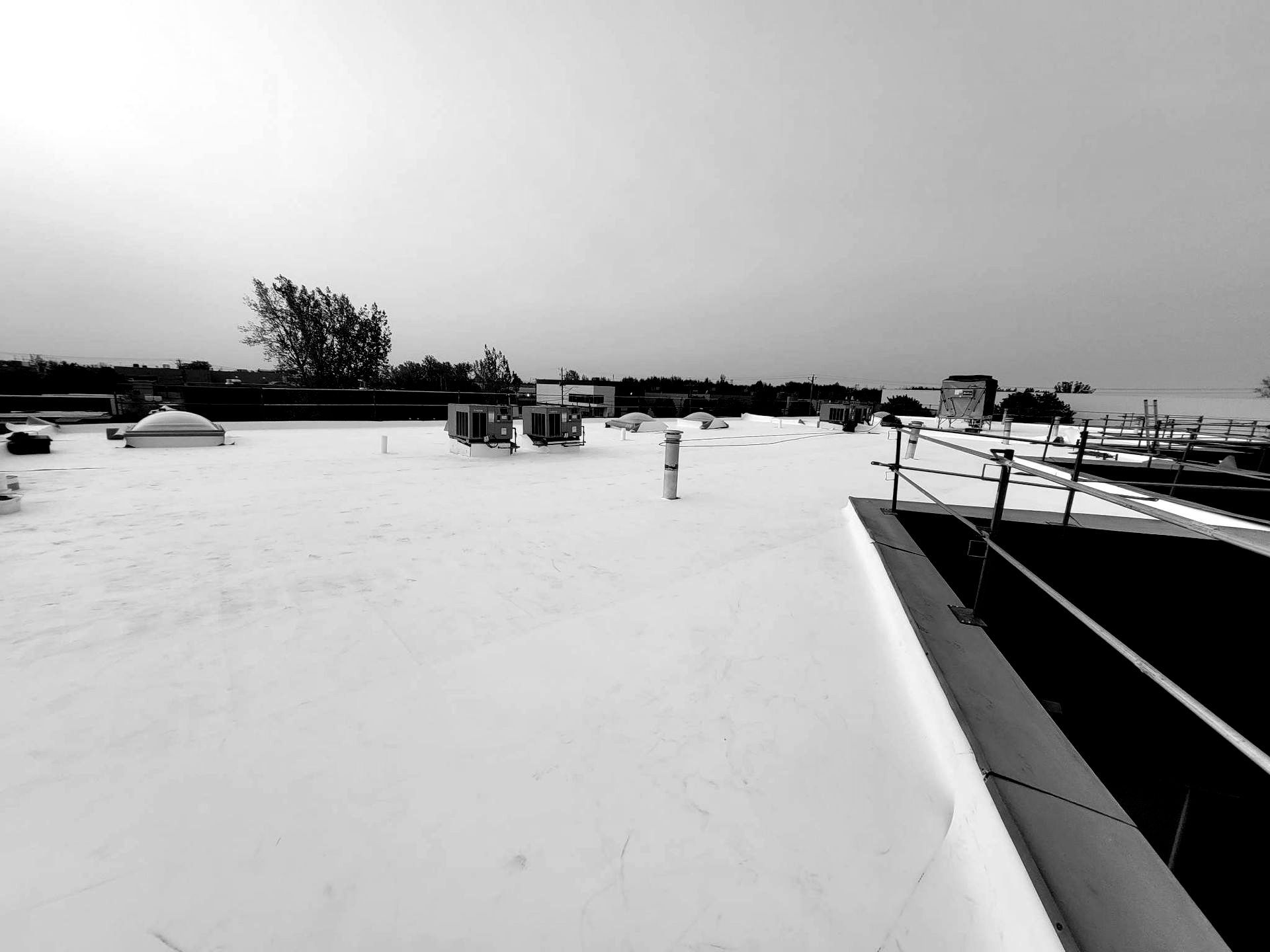Une photo en noir et blanc d'un toit avec beaucoup de neige dessus.