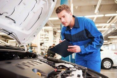 Car mechanic Checking engine - Auto Repair Service in Logan, UT