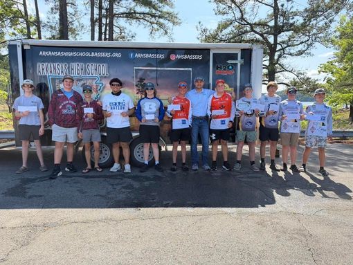 Group of cyclists standing in front of a Mooresville Bicycle booth at an outdoor event.