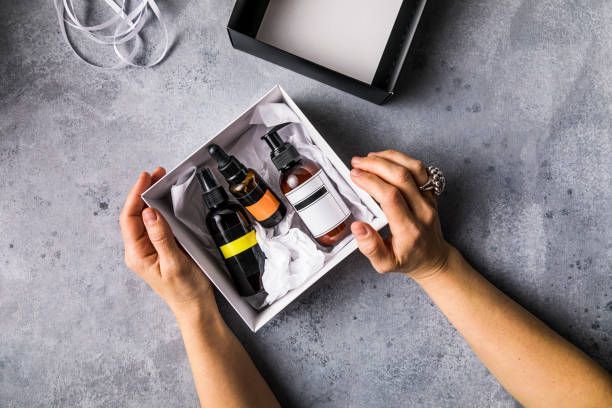 A woman is holding a box of bottles in her hands.