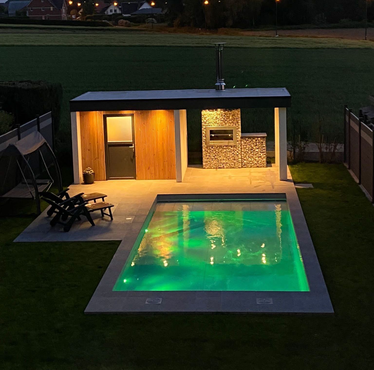 Une grande piscine est éclairée la nuit