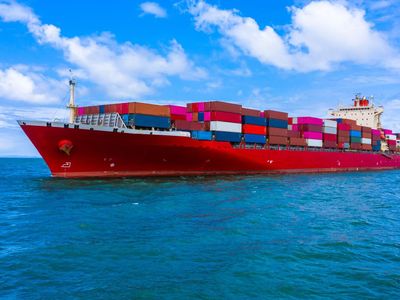 Un gran barco portacontenedores flota sobre un cuerpo de agua.