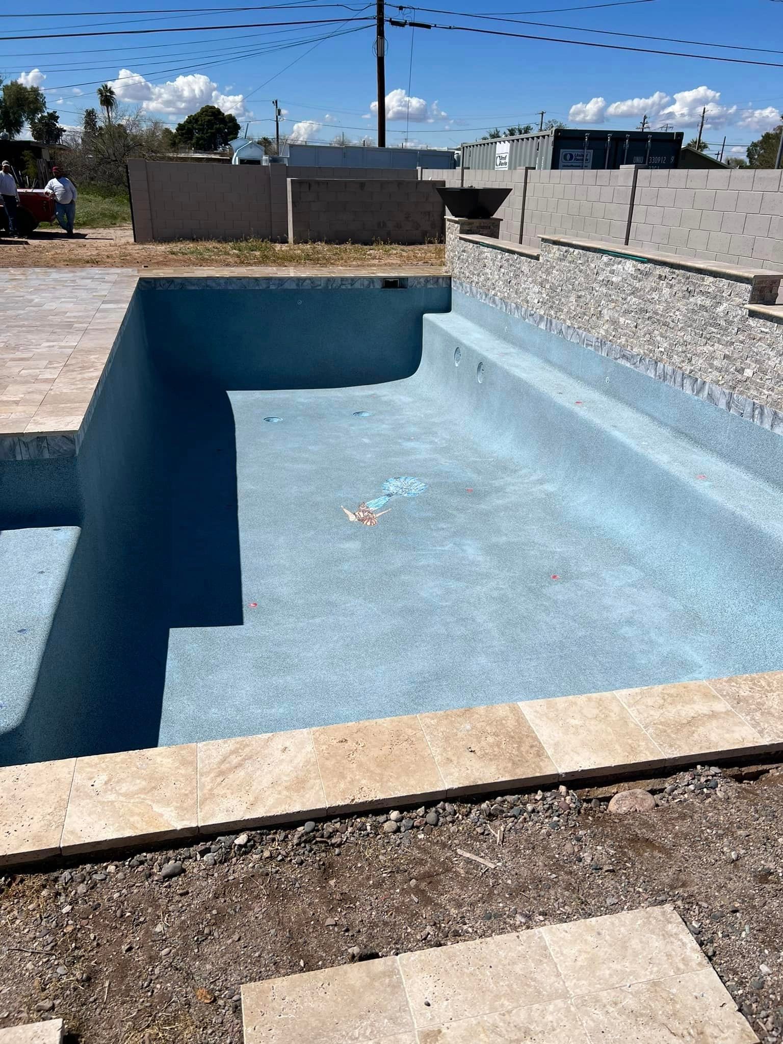 A large swimming pool is being built in a backyard