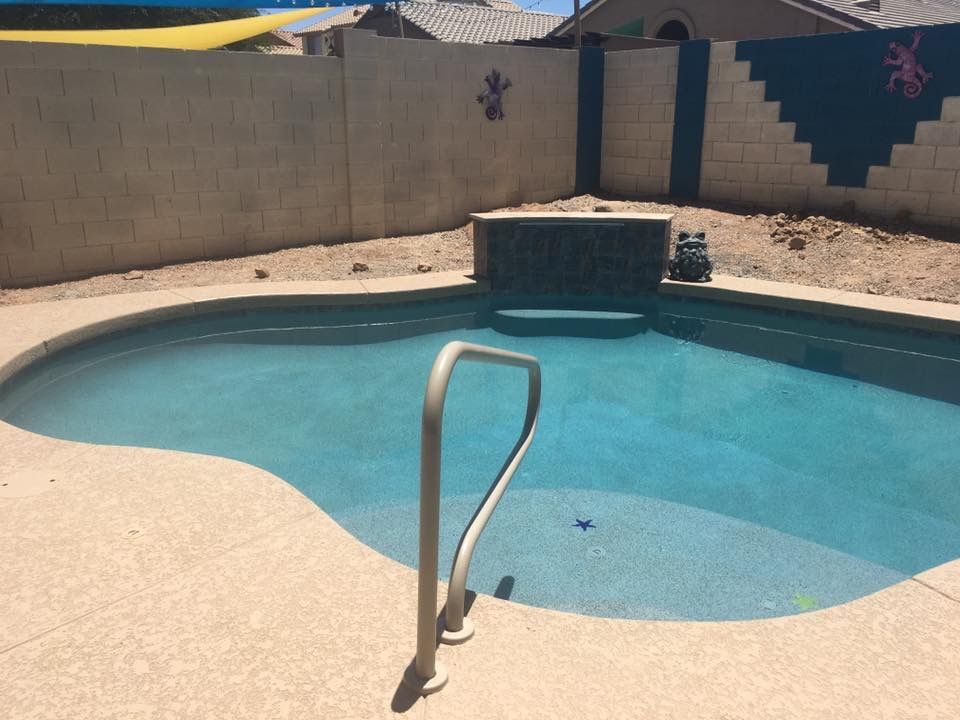 A swimming pool with a waterfall in the backyard