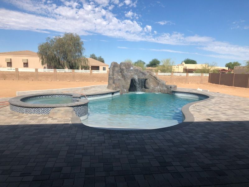 A large swimming pool with a waterfall in the middle