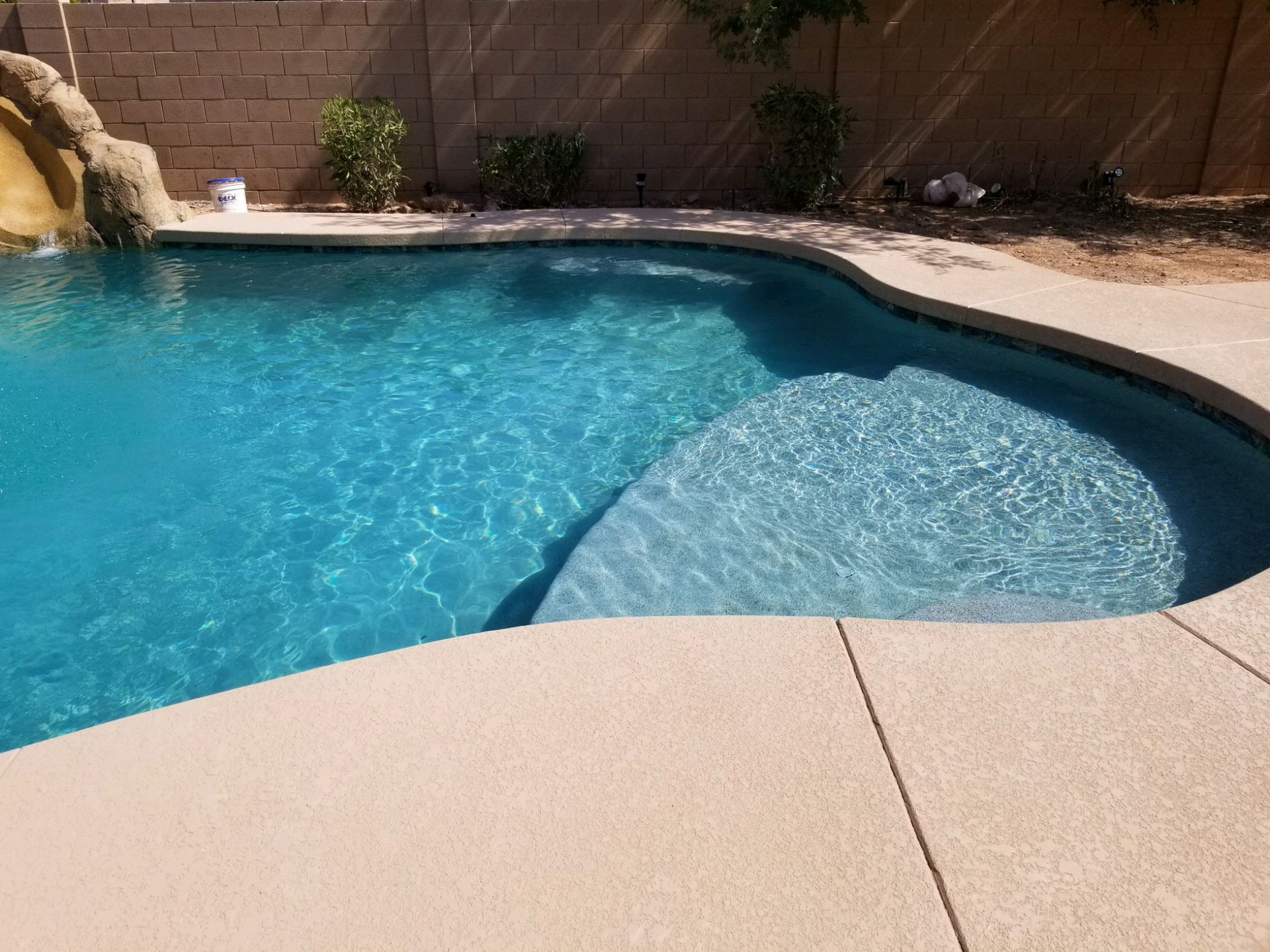 A large swimming pool with a slide in the backyard