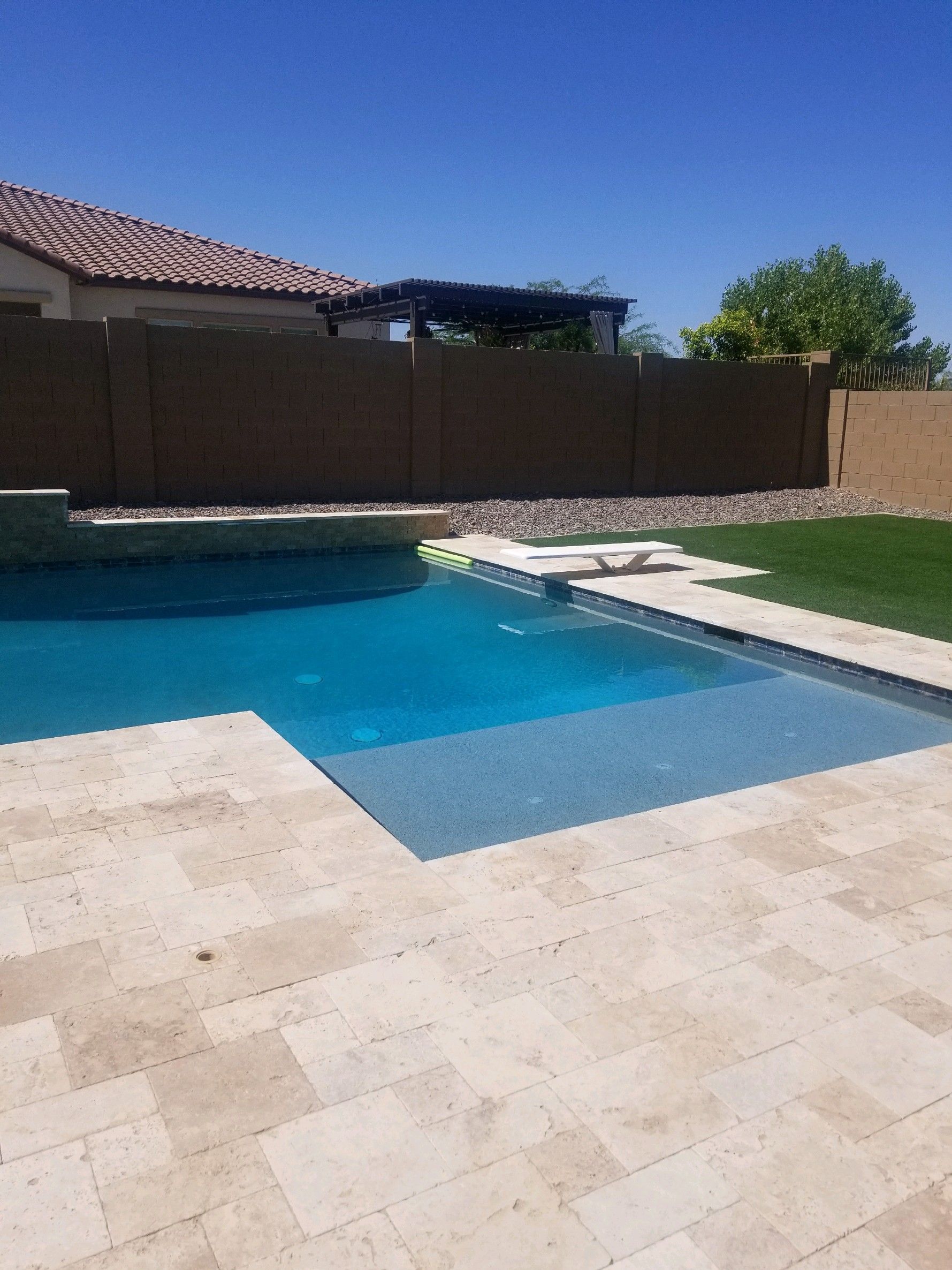 A large swimming pool with a fence in the background