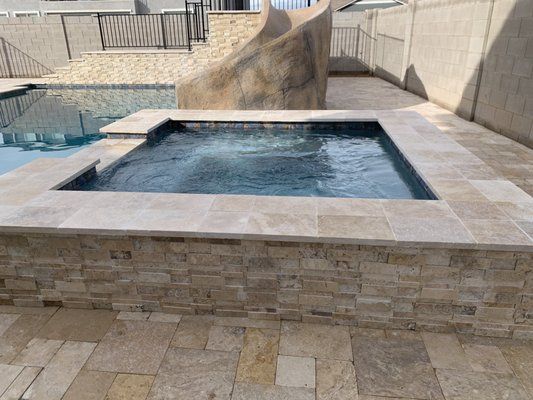 There is a large rock in the middle of the pool.
