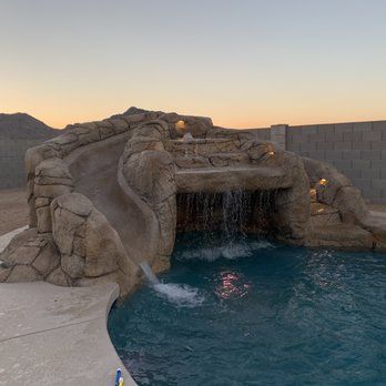 There is a waterfall in the middle of a pool.