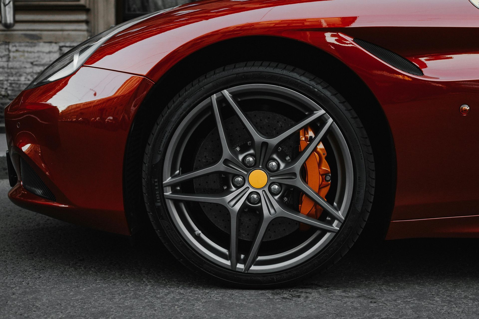 A red sports car is parked on the side of the road.