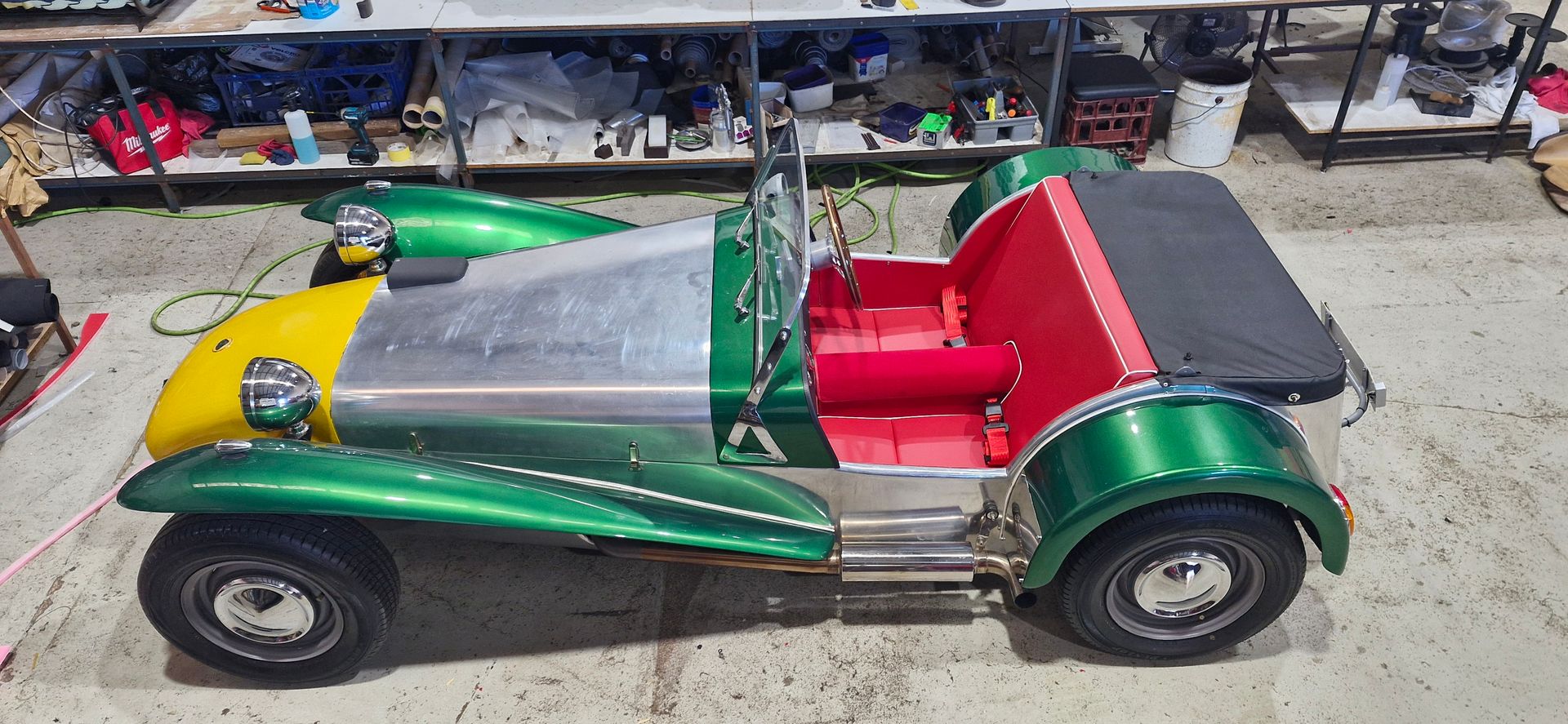 A green and yellow open-top sports car parked indoors — Tidy Trim Newcastle in Carrington, NSW