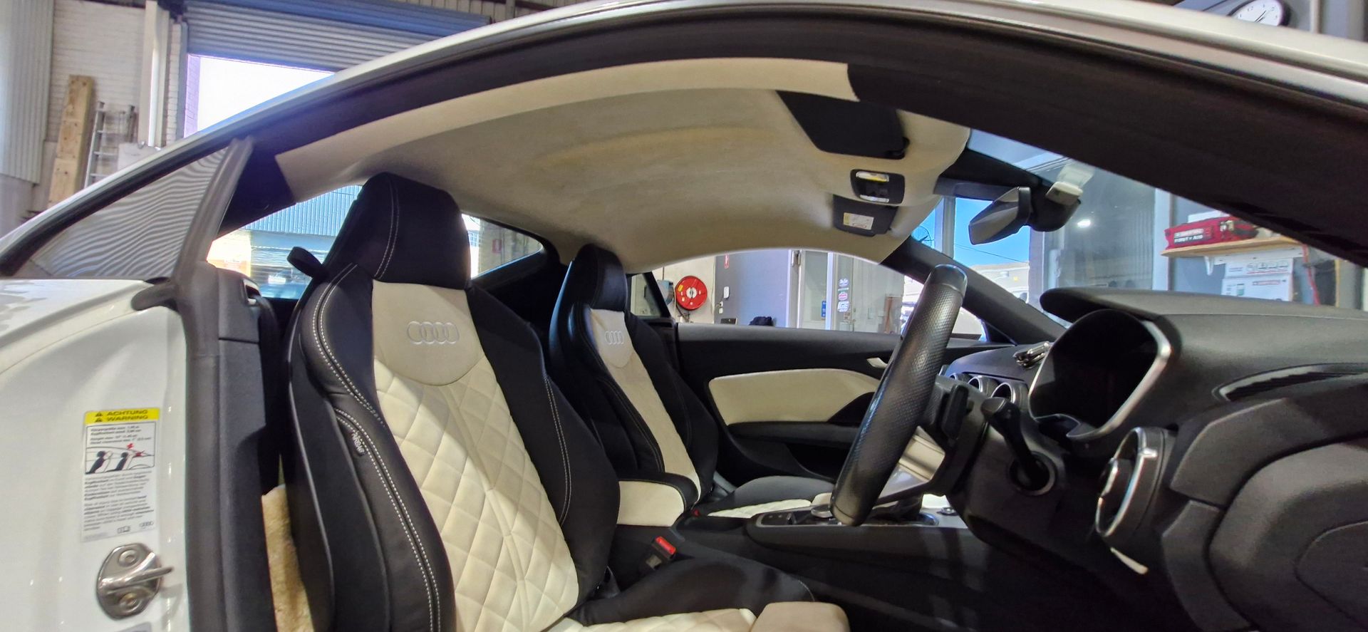 Black Quilted Car Seat In A Workshop Setting — Tidy Trim Newcastle in Carrington, NSW
