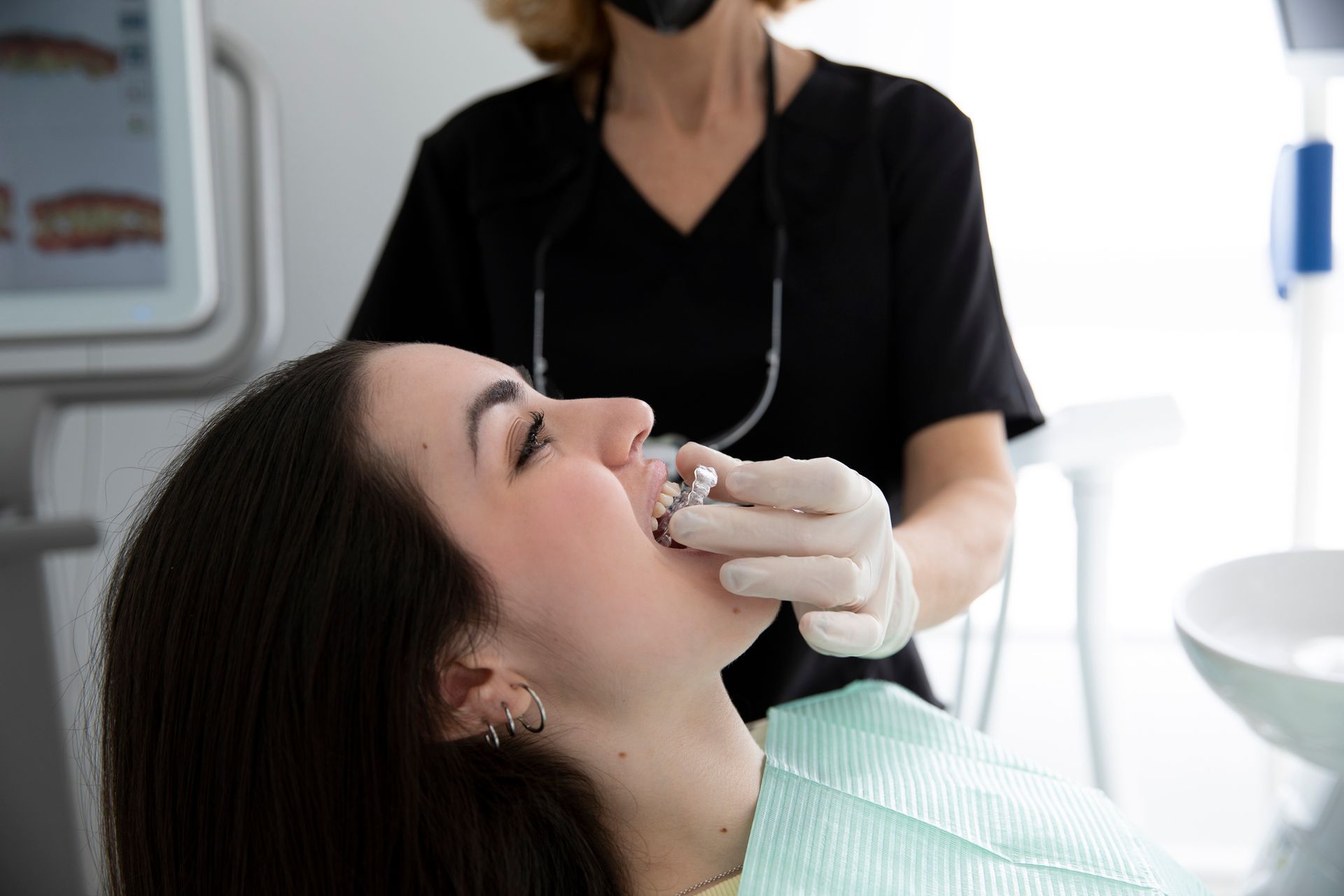 A woman getting custom denture repair as dentist examines her teeth in a professional dental clinic.