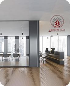 Modern office interior with wooden floors, windows, and logo.