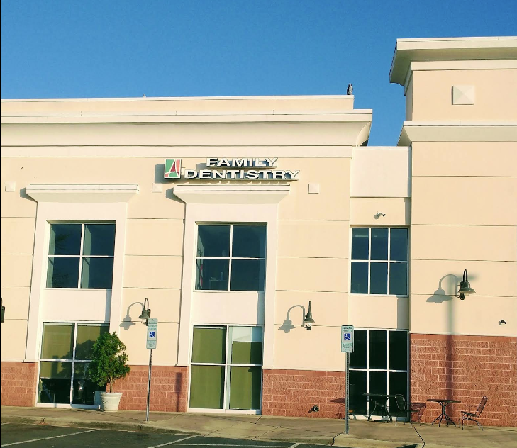 A white building with a sign that says family dentistry