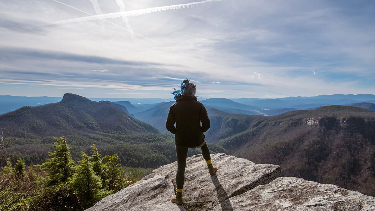 A person stands on a mountain summit.