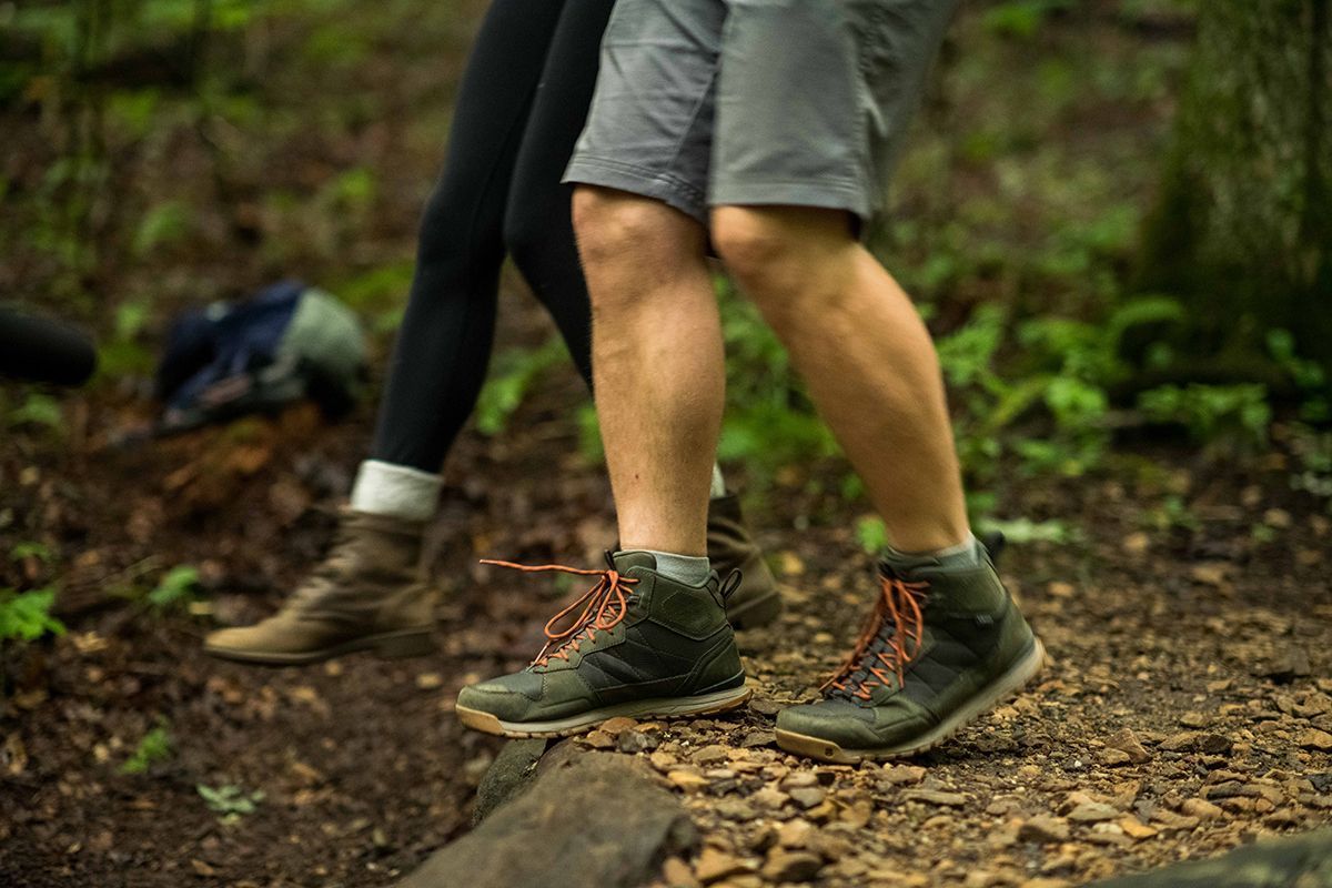 A man's feet are shown walking on a trail.