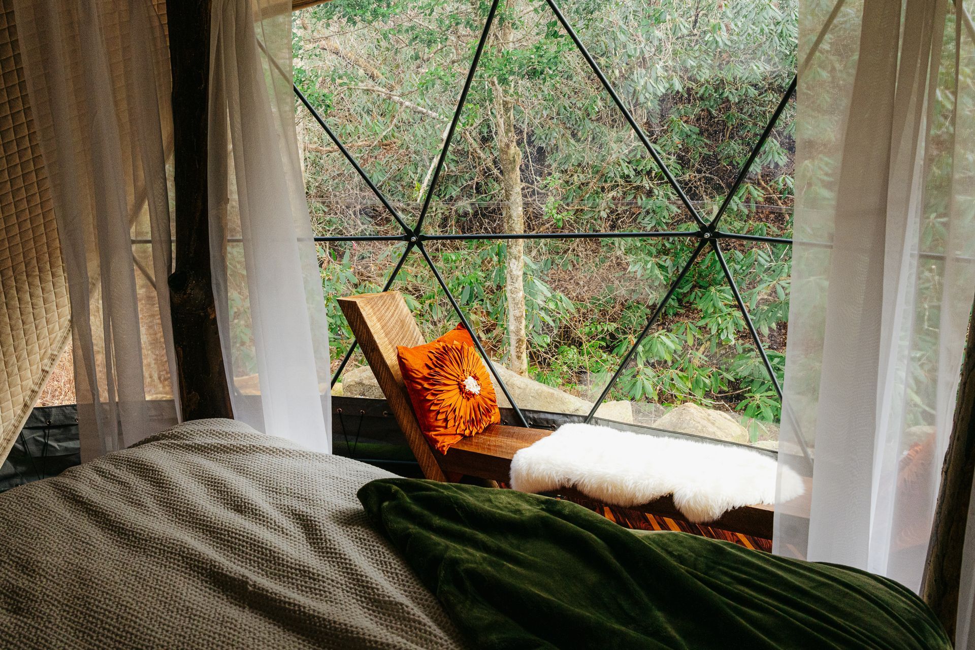 A bench looking out a camping dome window