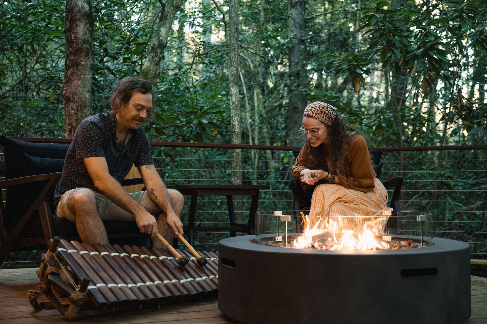 A couple plays music by a fire