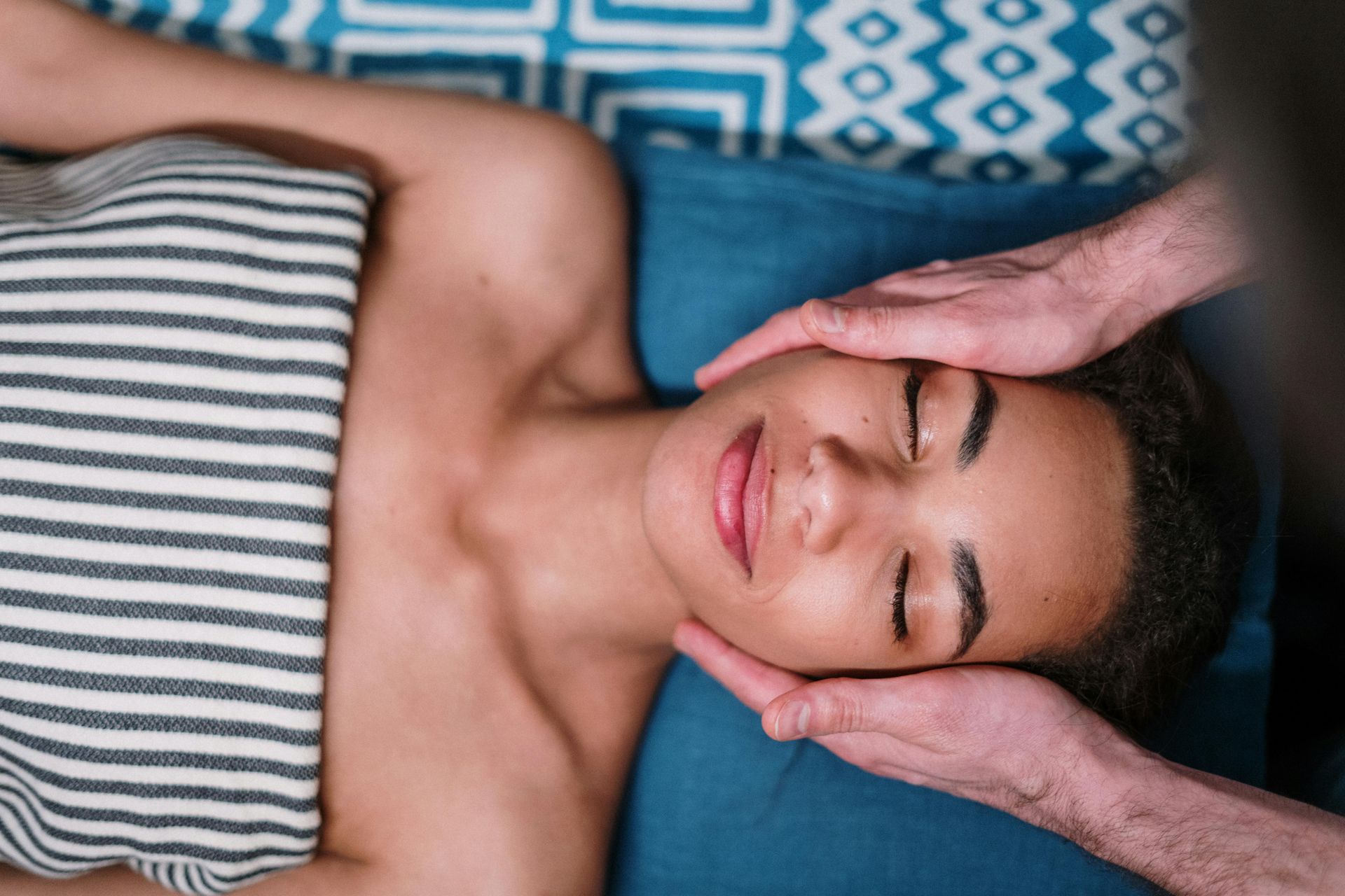 A woman is getting a facial massage at a spa.
