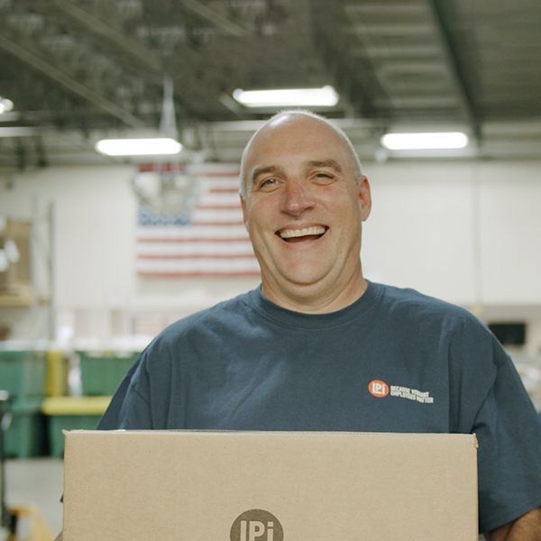 A man holding a box smiling for the camera.