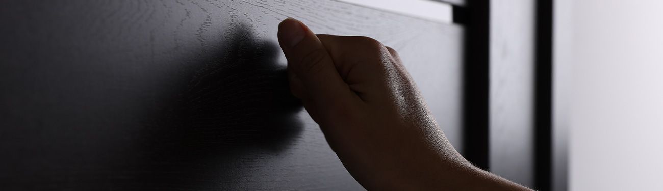 A close up of a person 's hand knocking on a door.