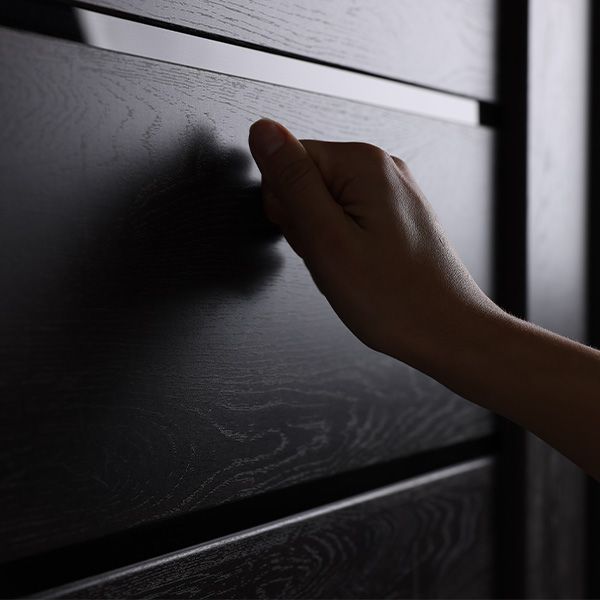 A person 's hand is knocking on a wooden door.