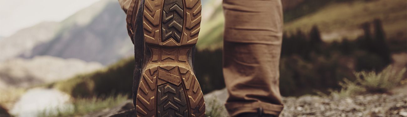 A close up of a person 's feet wearing hiking boots.