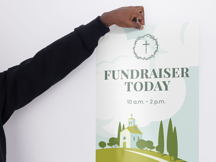 Hand placing a white fundraiser poster with green church illustration and “FUNDRAISER TODAY 10 a.m.-2 p.m.”