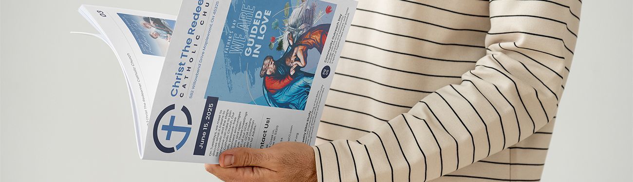 A person in a striped shirt is holding a church bulletin in their hands.