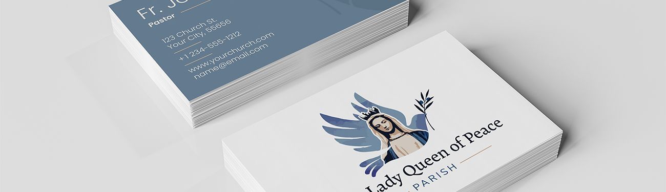 Two stacks of business cards on a table with a logo of Mary with a dove behind her.