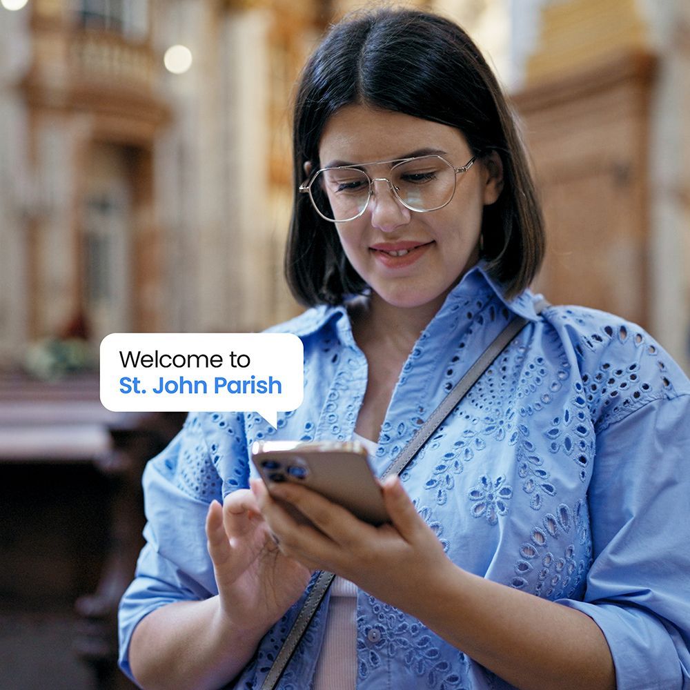 Woman inside a church looking at her phone. The screen reads 