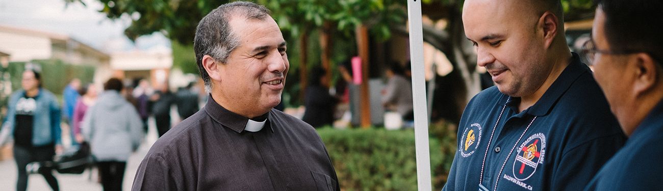 A priest is talking to parishioners.