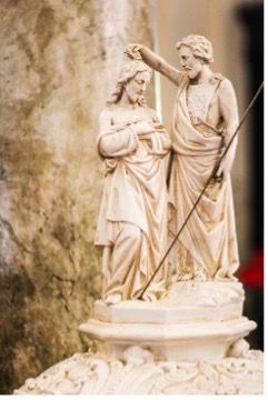 A close up of a statue of John the Baptist baptizing Jesus.