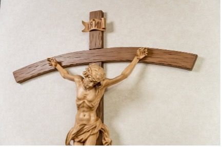 A wooden cross with a statue of Jesus on it.