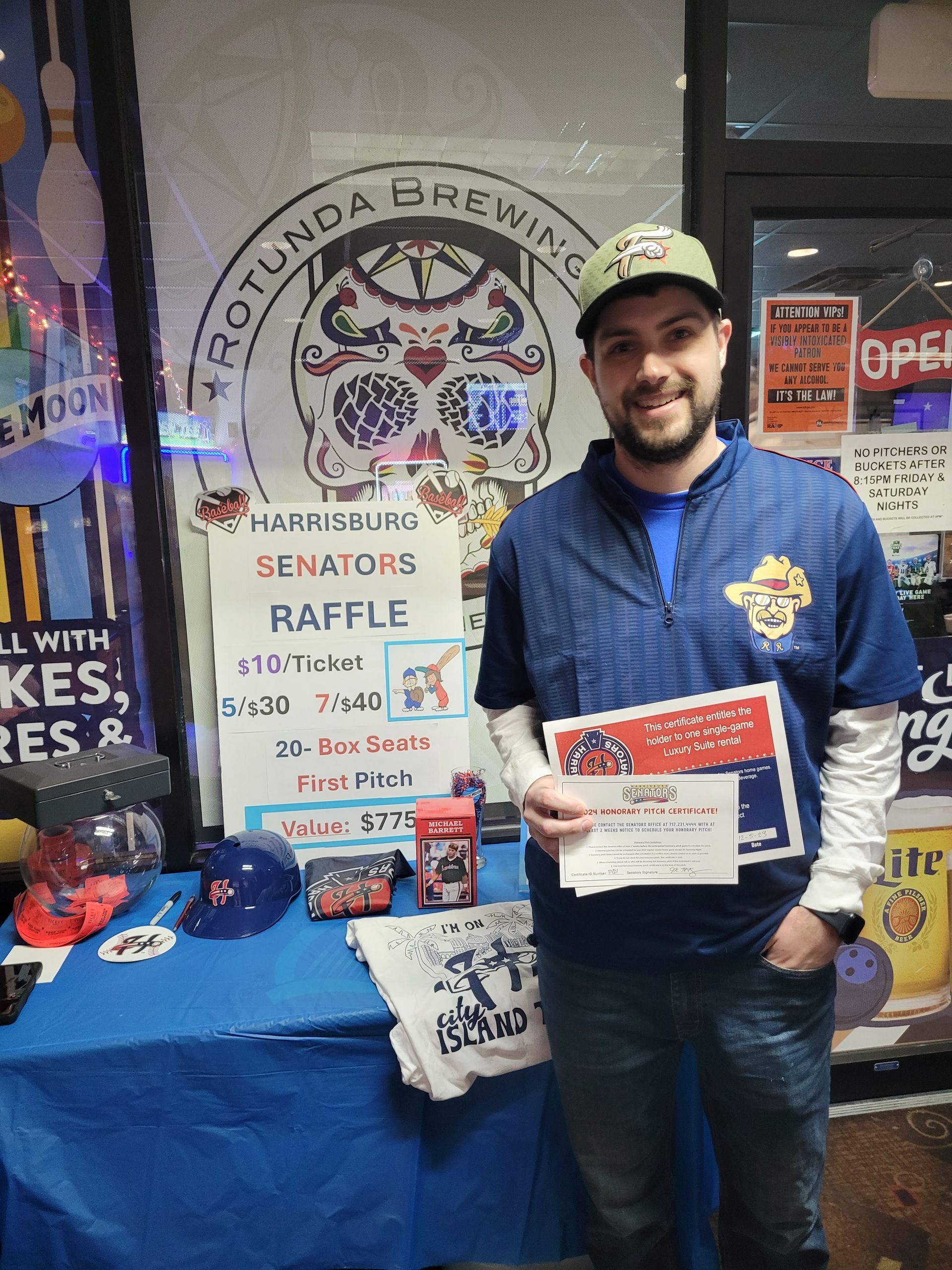 A man is standing in front of a table with a sign that says senators raffle