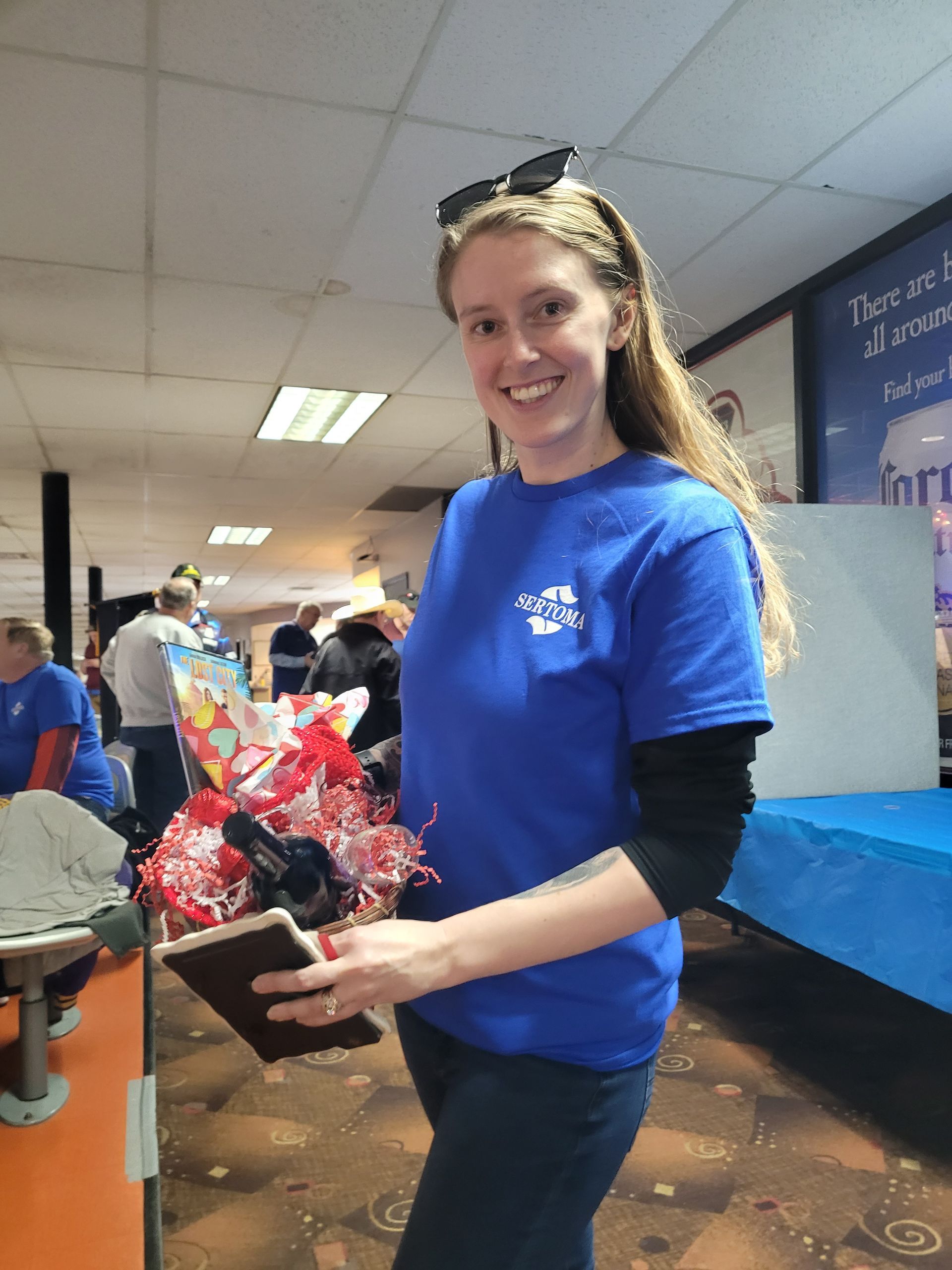 A woman in a blue shirt is holding a book